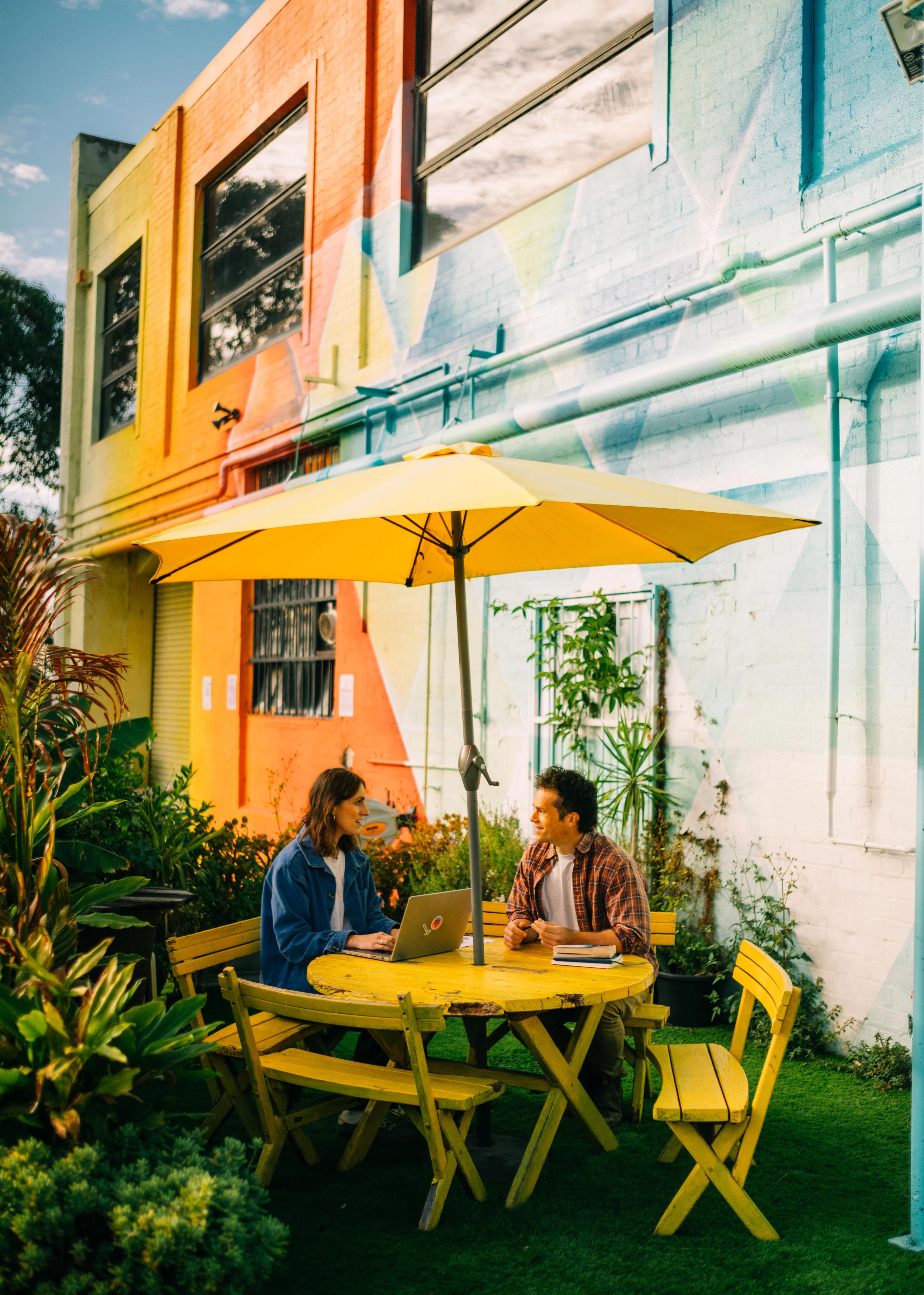 Two tenants sat oustide on a yellow table.