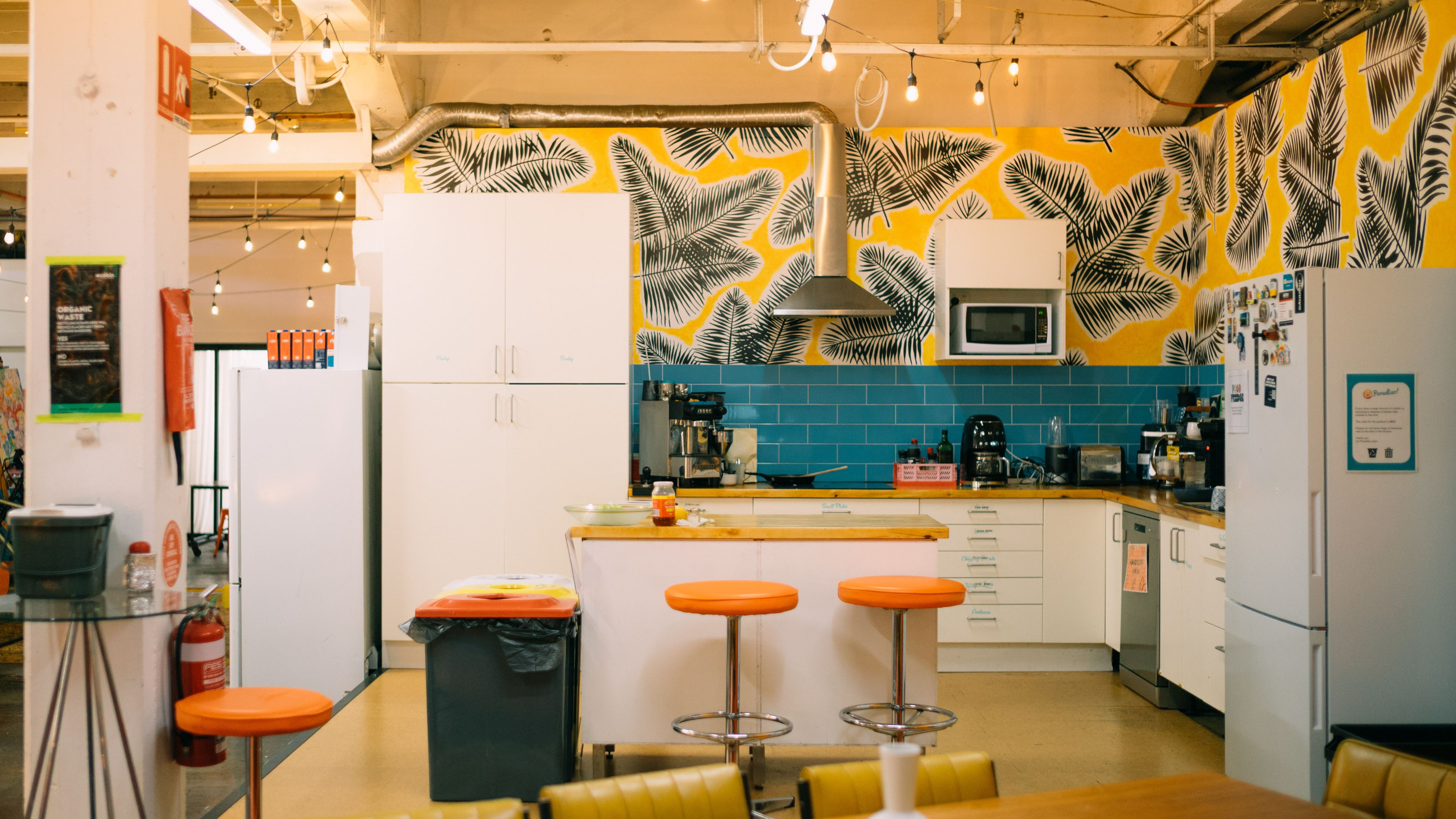 A full kitchen with cupboards, fridges, microwaves and a stove