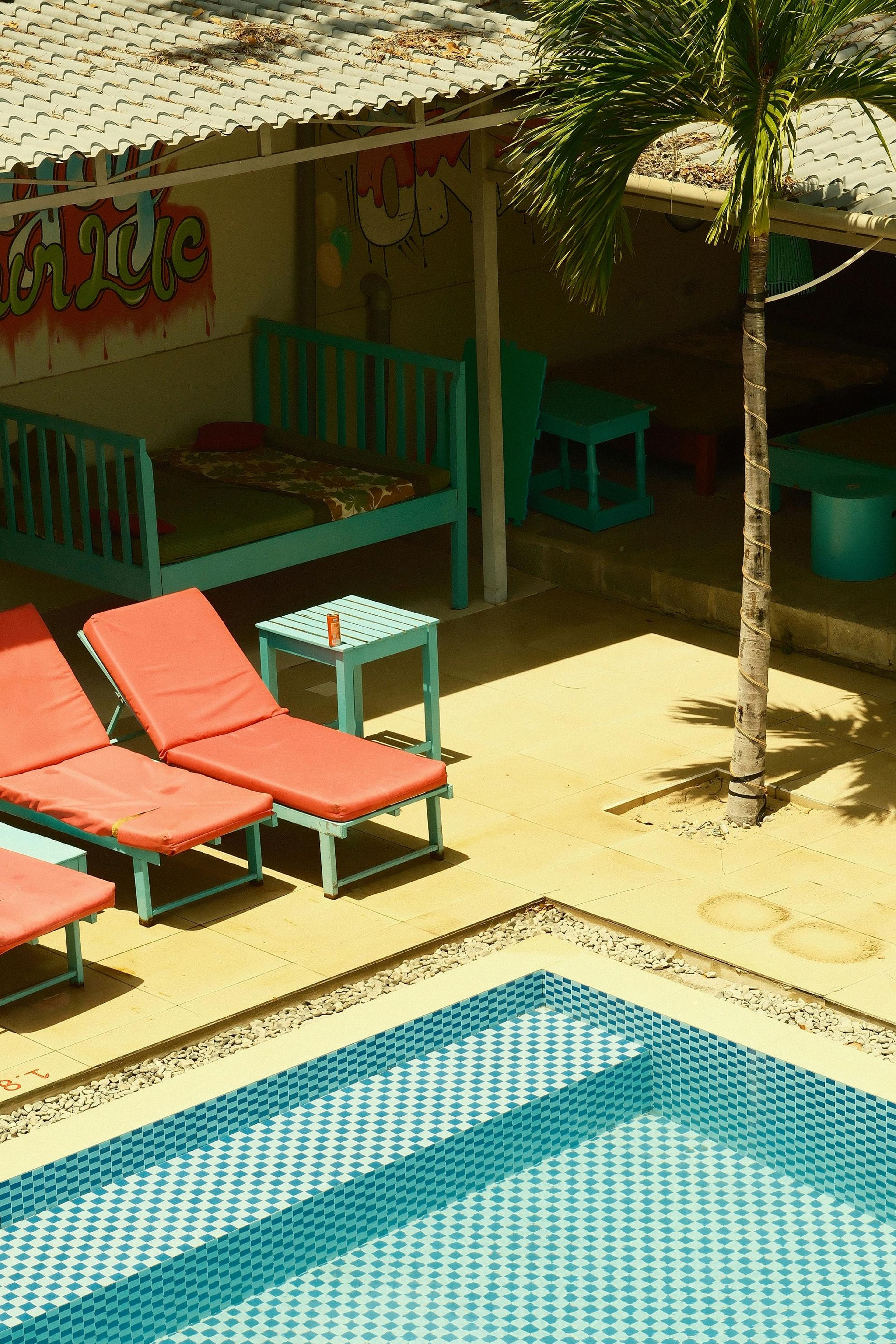 Some colourful fold-out chairs by an outdoor pool