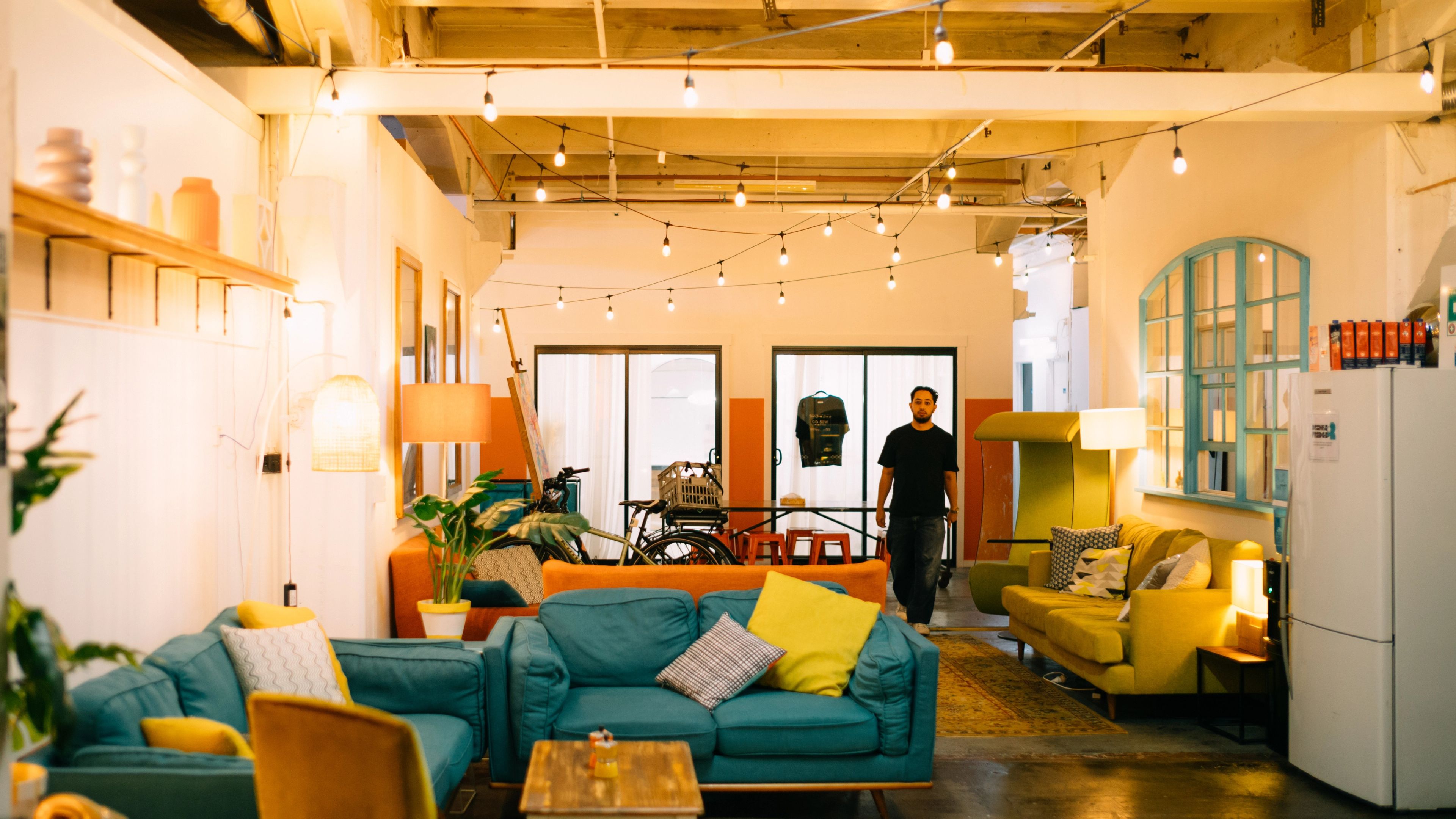 A walkway full of couches, plants, and lights
