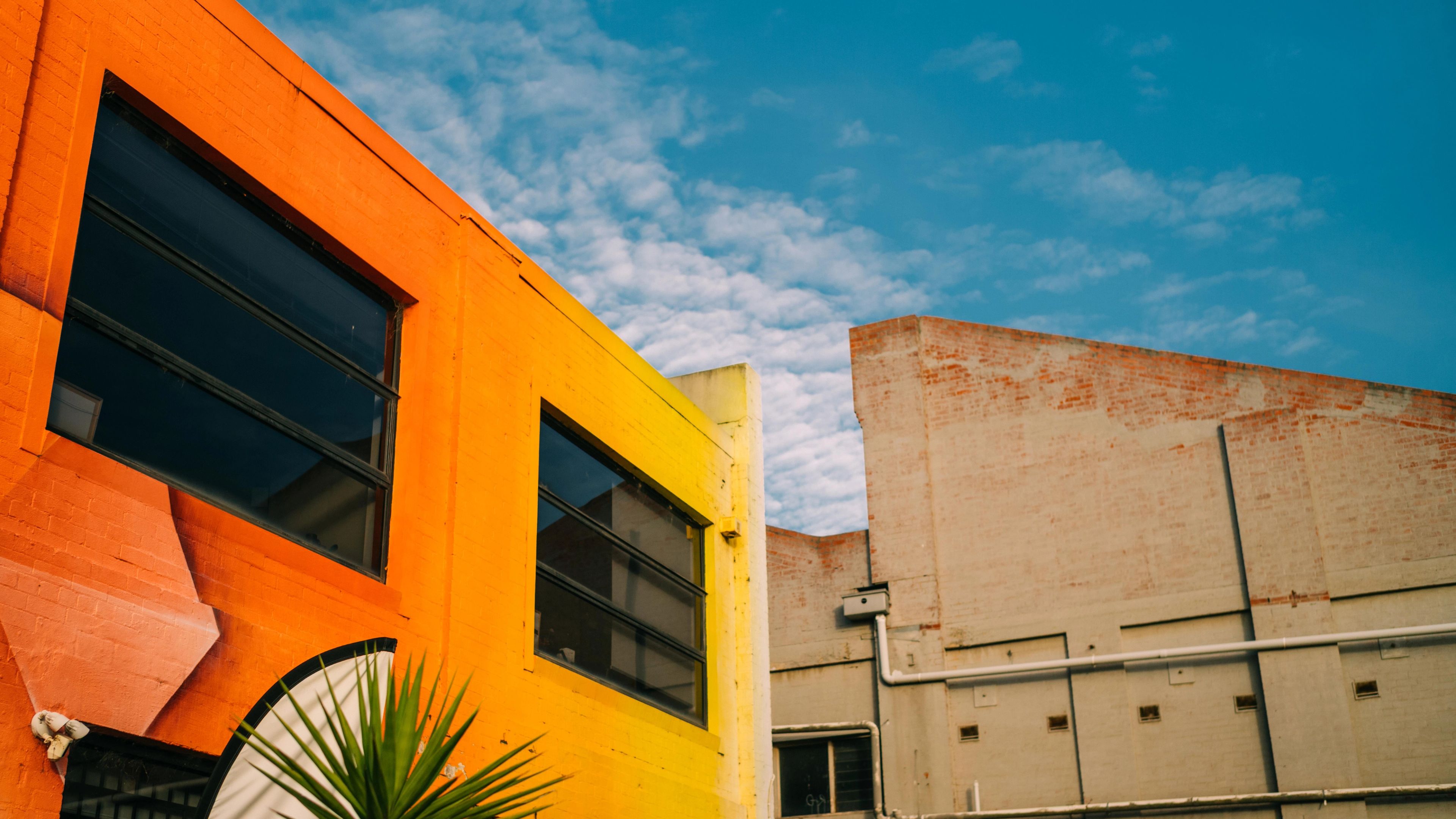 A shot of the sky framed by two warehouse buildings