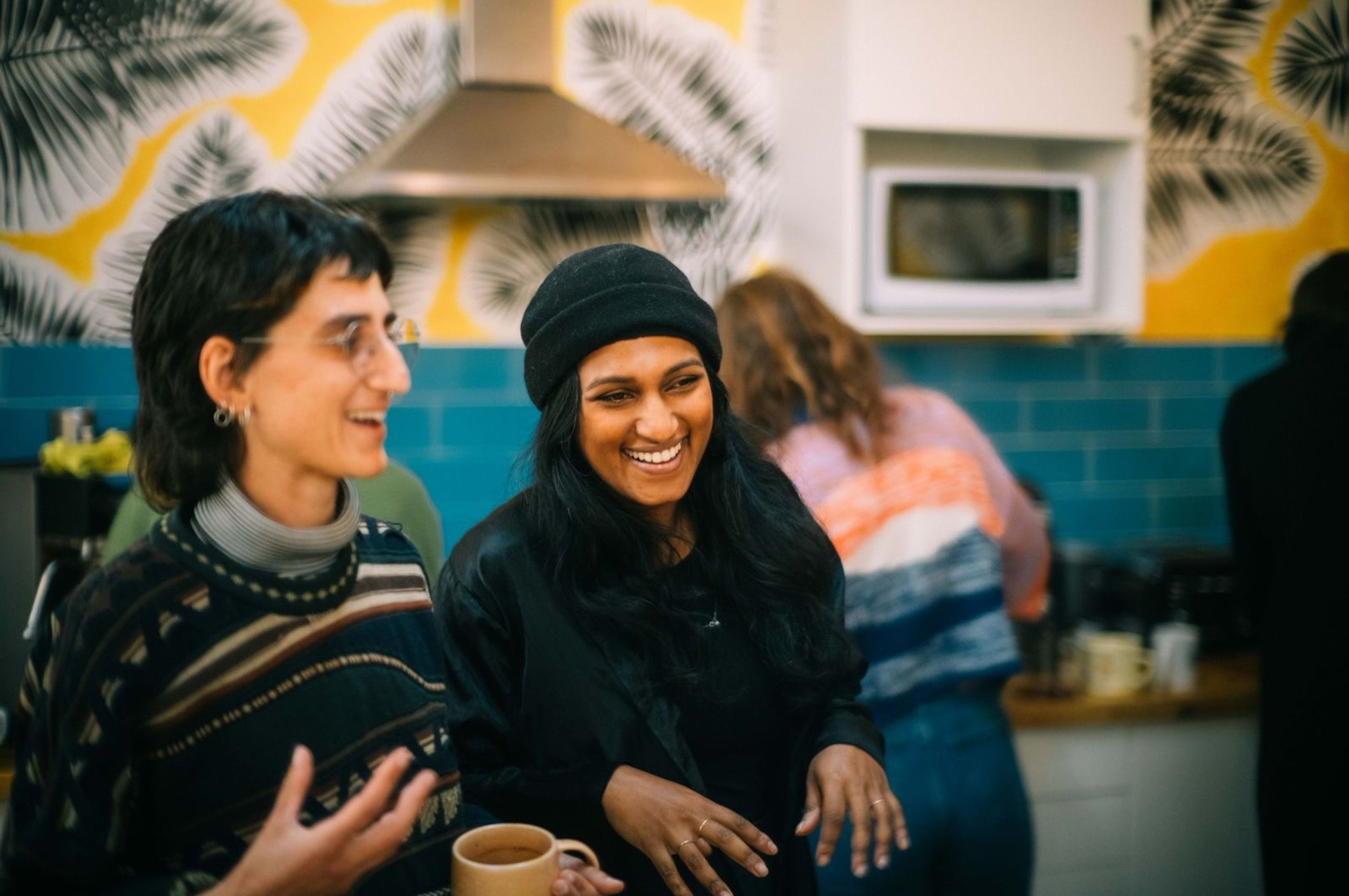 Two CoParadiso tenants laughing in the kitchen