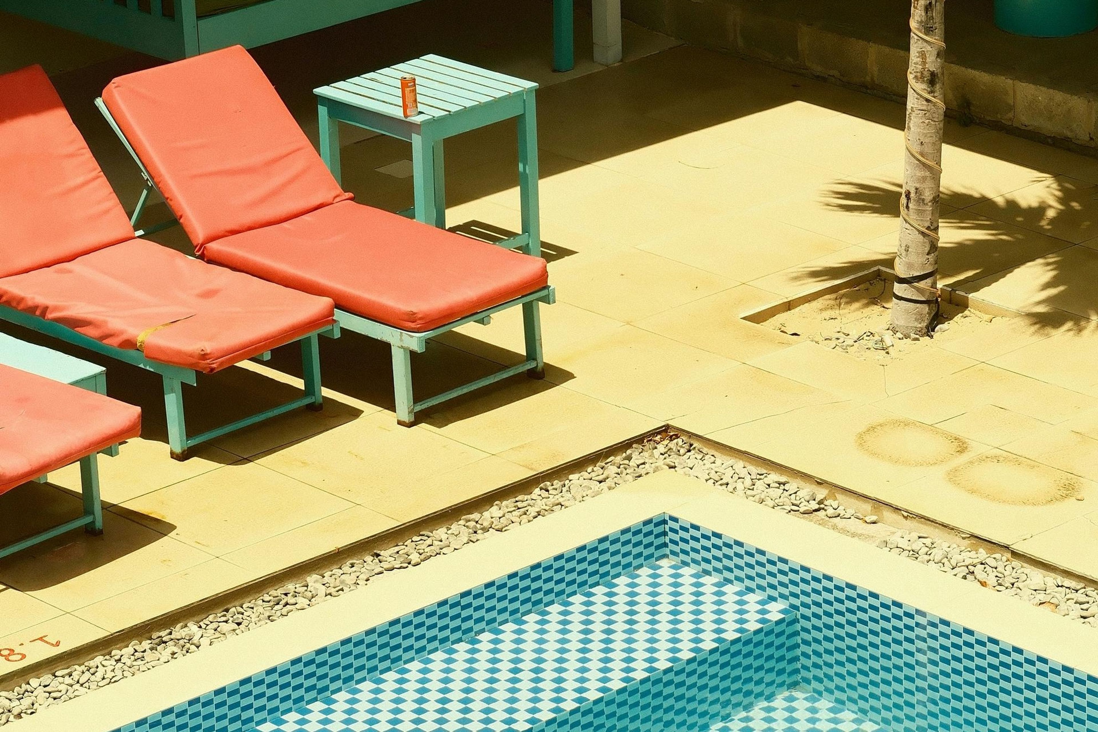 Some colourful fold-out chairs by an outdoor pool