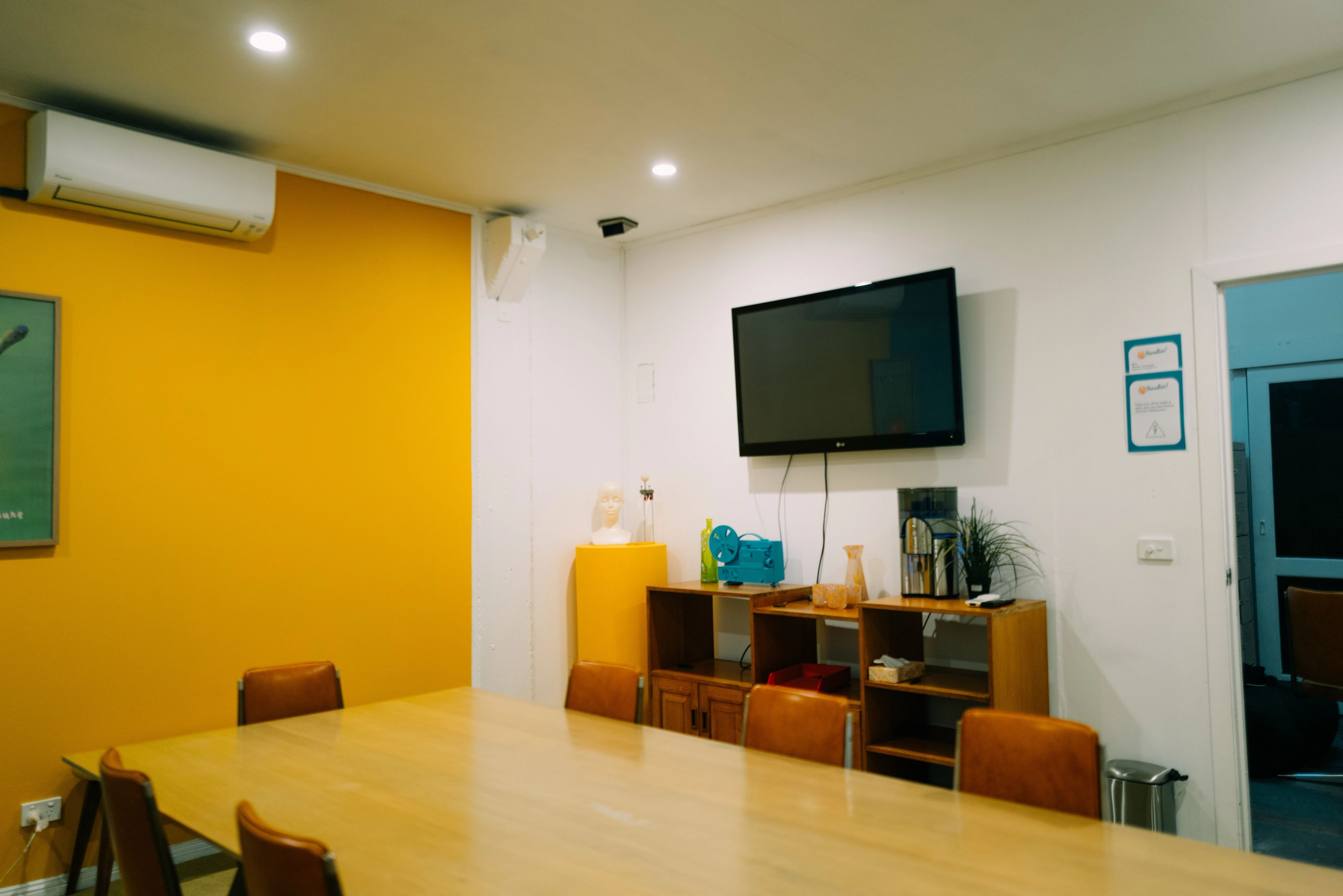 A brightly lit room with a long table and whiteboard