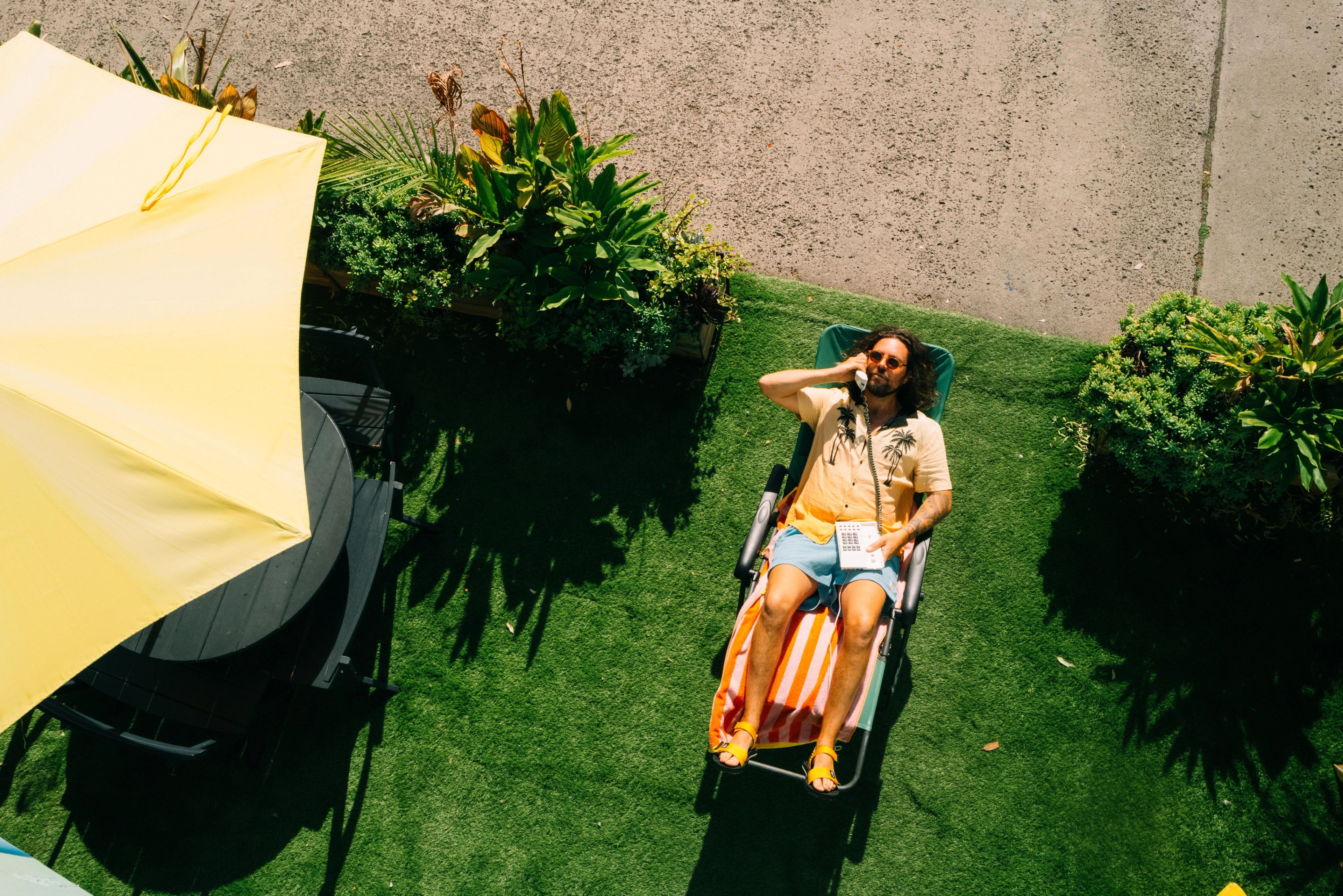 Owner of Co Paradiso, Kim, on a reclined arm chair outside on astro turf. 