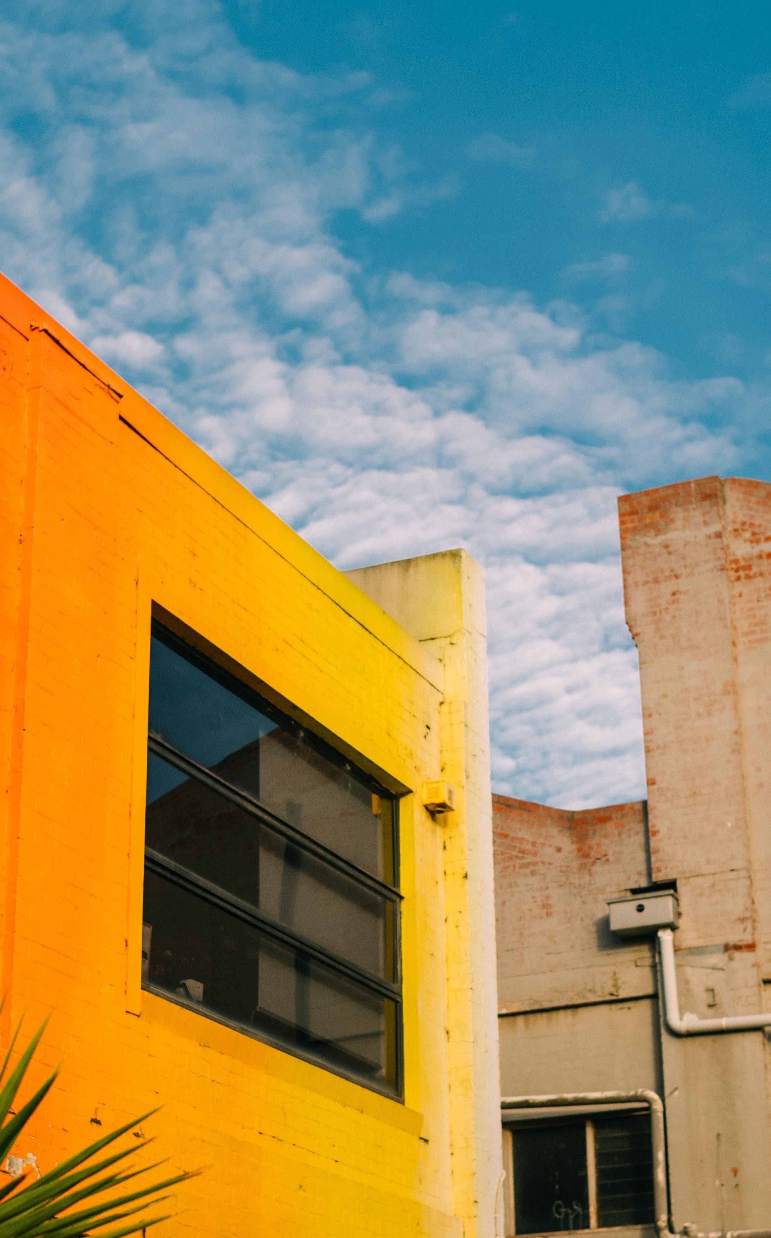 A shot of the sky framed by two warehouse buildings
