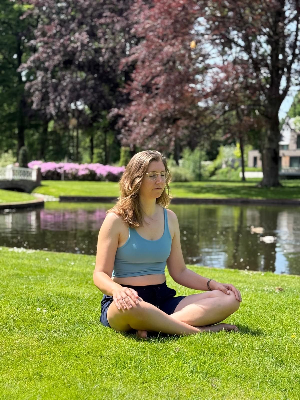 Hanneke in een yogahouding in de Engelse tuin