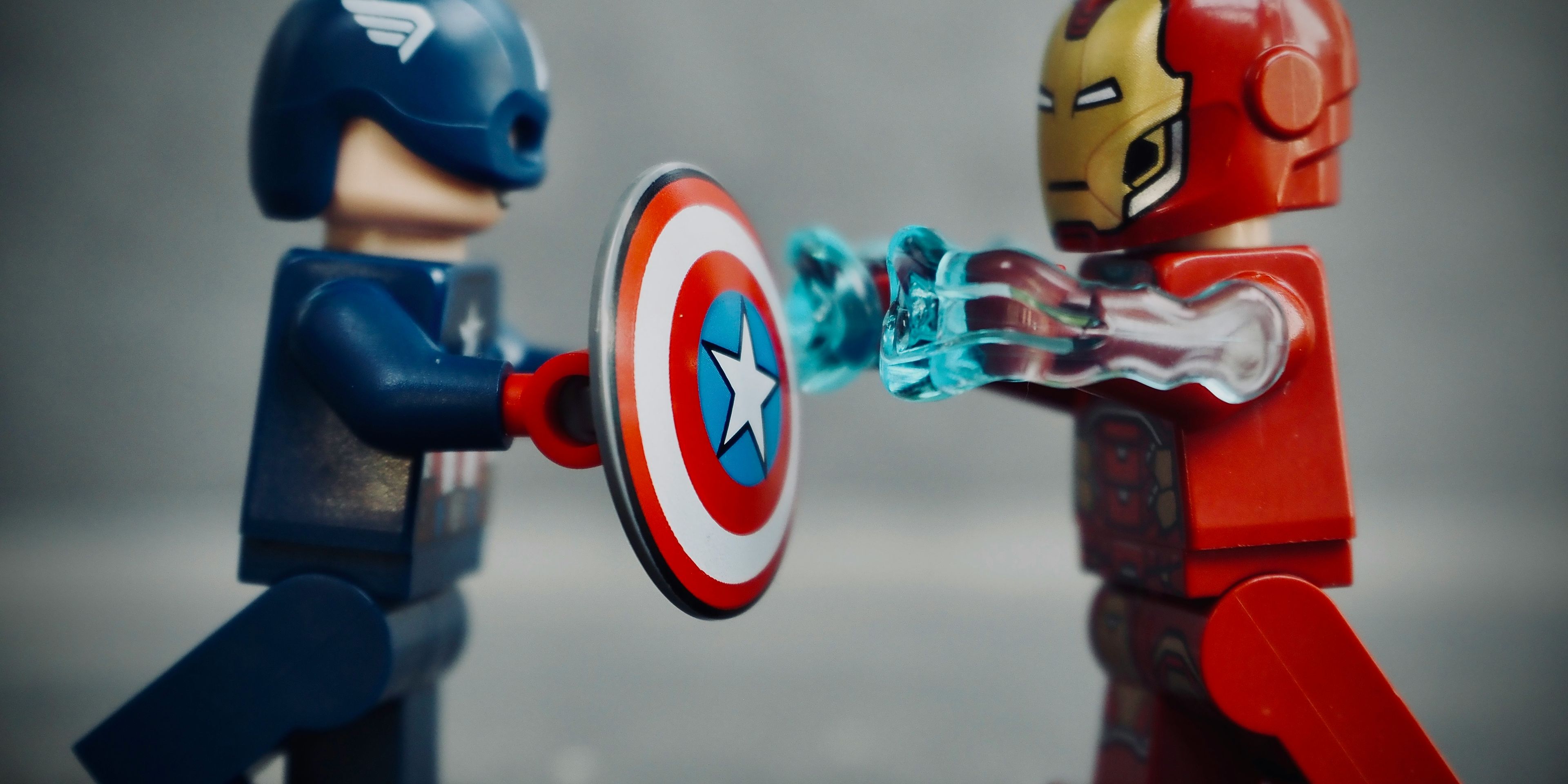 captain america and iron man are fighting with a shield .