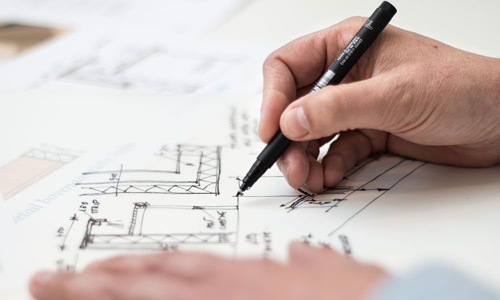 person drawing blueprints