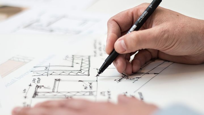 person drawing blueprints