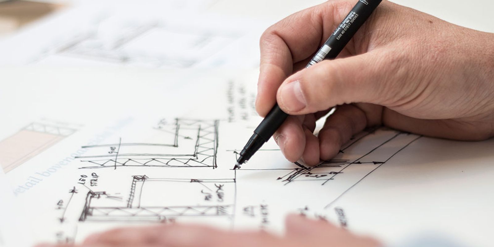 person drawing blueprints