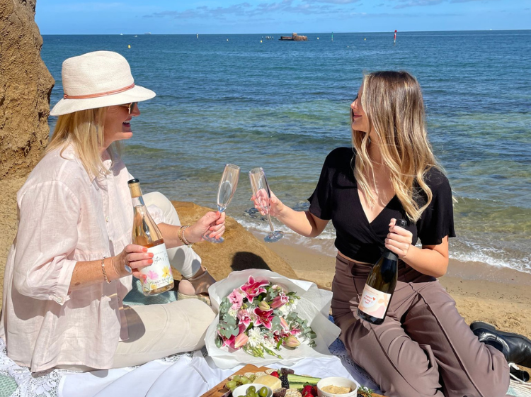 Mother and daughter enjoying personalised wine on the beach