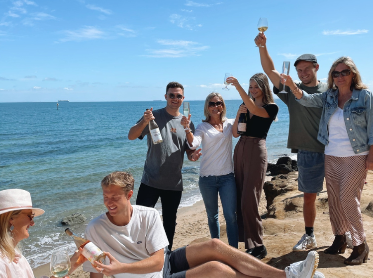 family and friend enjoying personalised wine on the beach