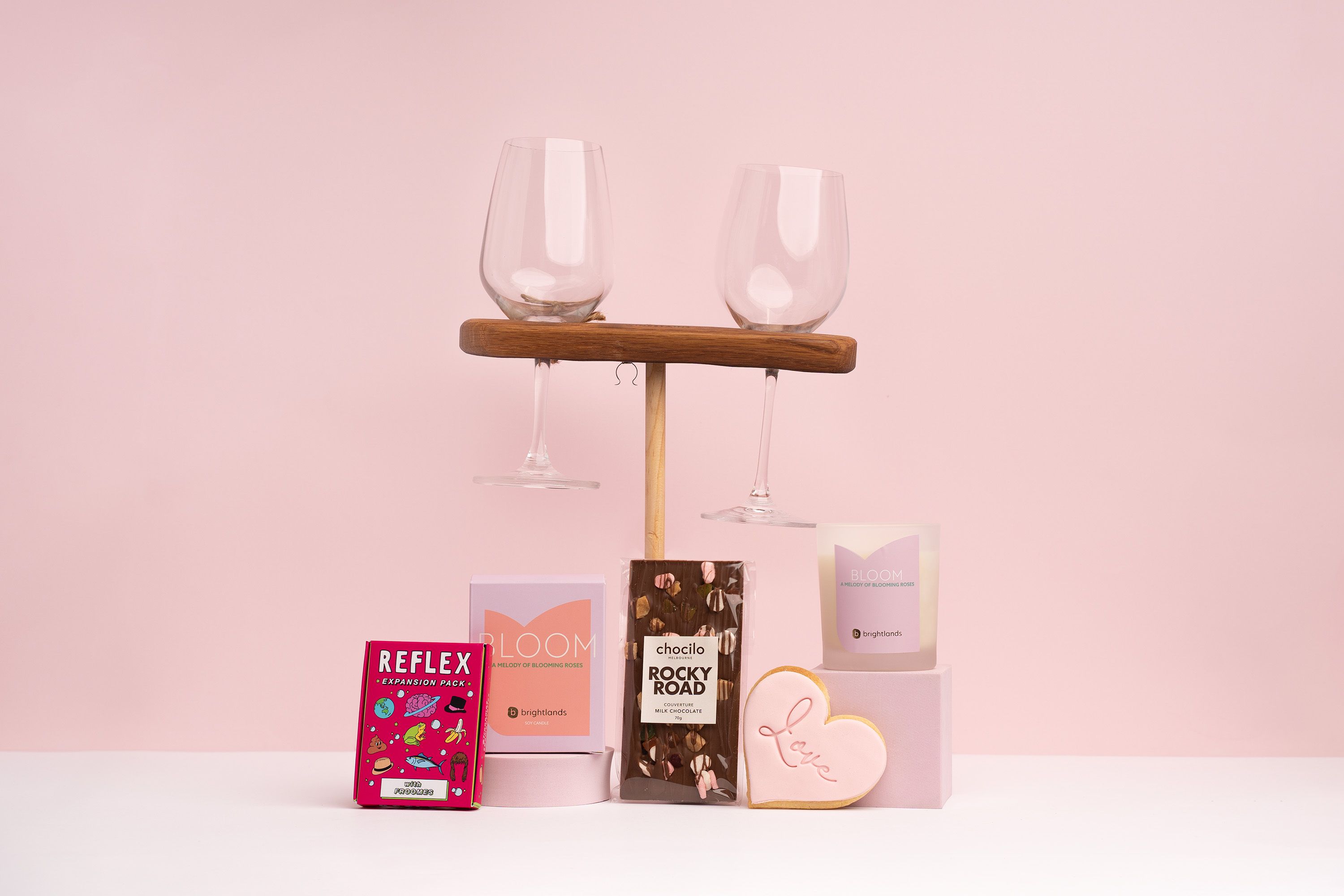 range of add-ons to go in a gift box with a rocky road bar, scented candle, connection cards, wine glass picnic stake and love cookie