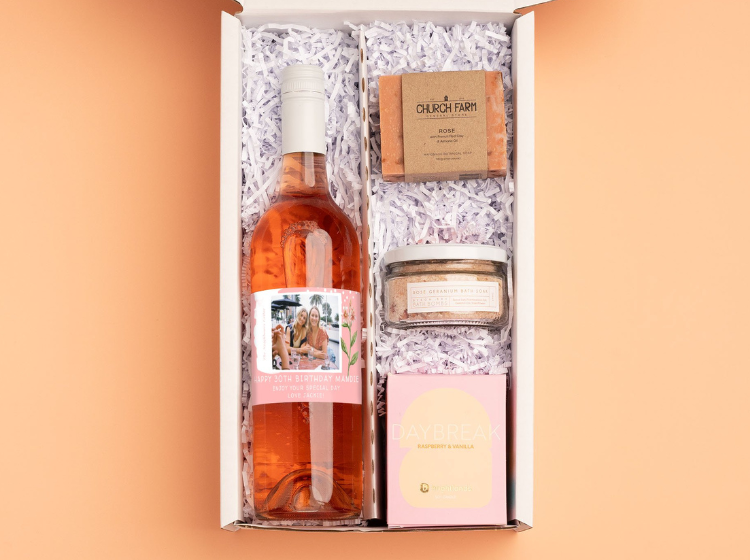 Personalised rosé bottle in a gift box with a scented candle, bath salts and hand soap
