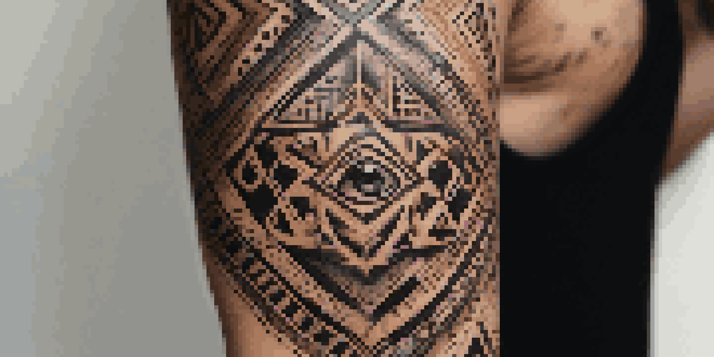 A close-up view of a tribal tattoo on a forearm, featuring intricate patterns and deep black ink under soft natural light.