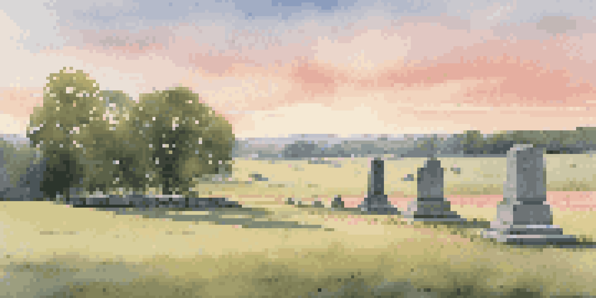 A serene view of the Gettysburg battlefield at dawn, showcasing a monument and lush green fields under a colorful sky.