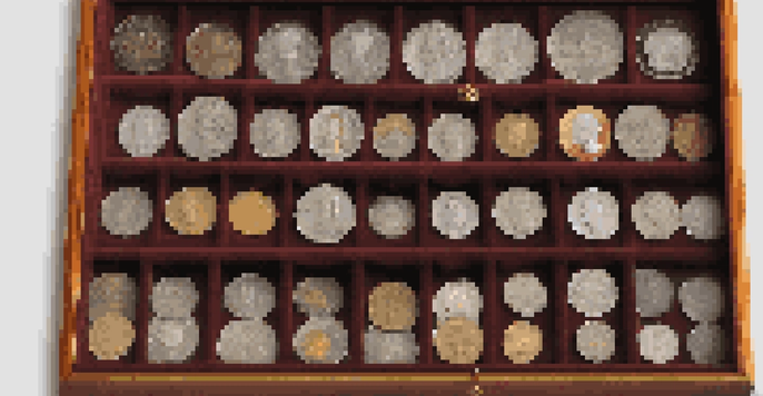 A close-up view of a neatly organized coin collection in a wooden display case, featuring various coins illuminated by soft natural light.