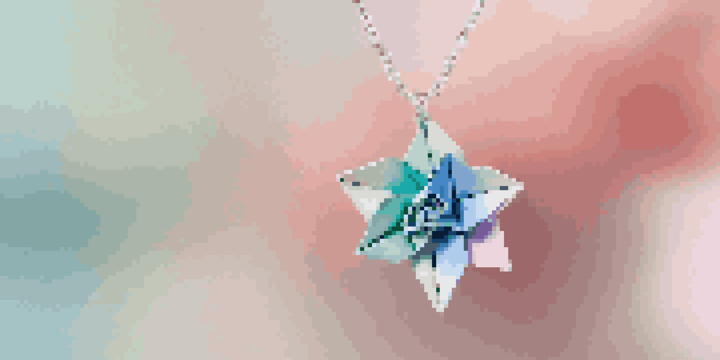 A close-up view of a colorful origami flower pendant on a silver chain, with intricate paper folds and a soft background.