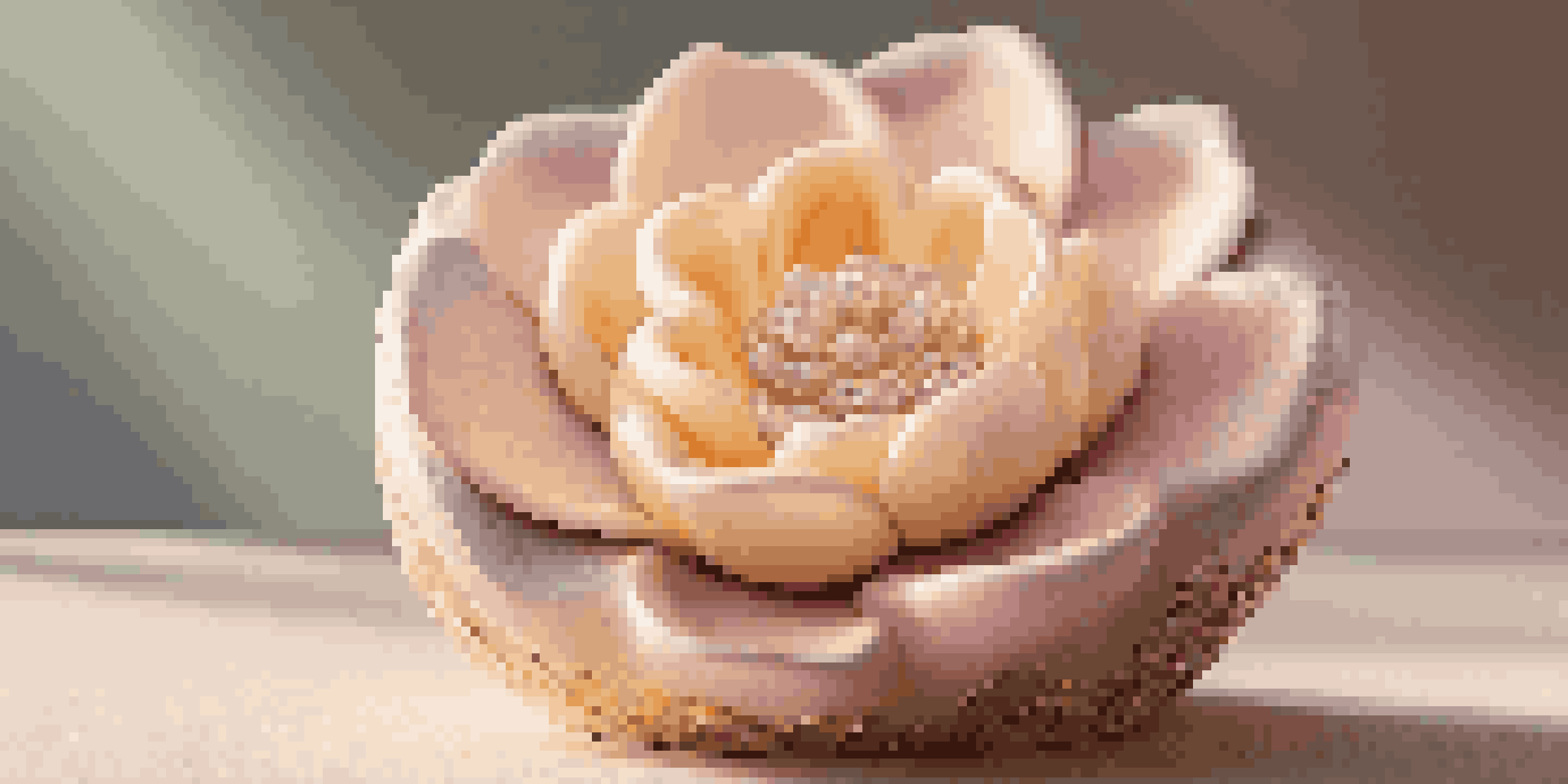 A soap sculpture shaped like a delicate flower, with warm lighting showcasing its details against a pastel gradient background.