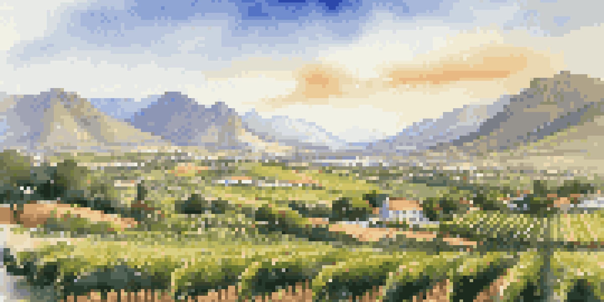 A scenic view of the Cape Winelands in South Africa, with rolling vineyards and mountains in the background under a sunny sky.