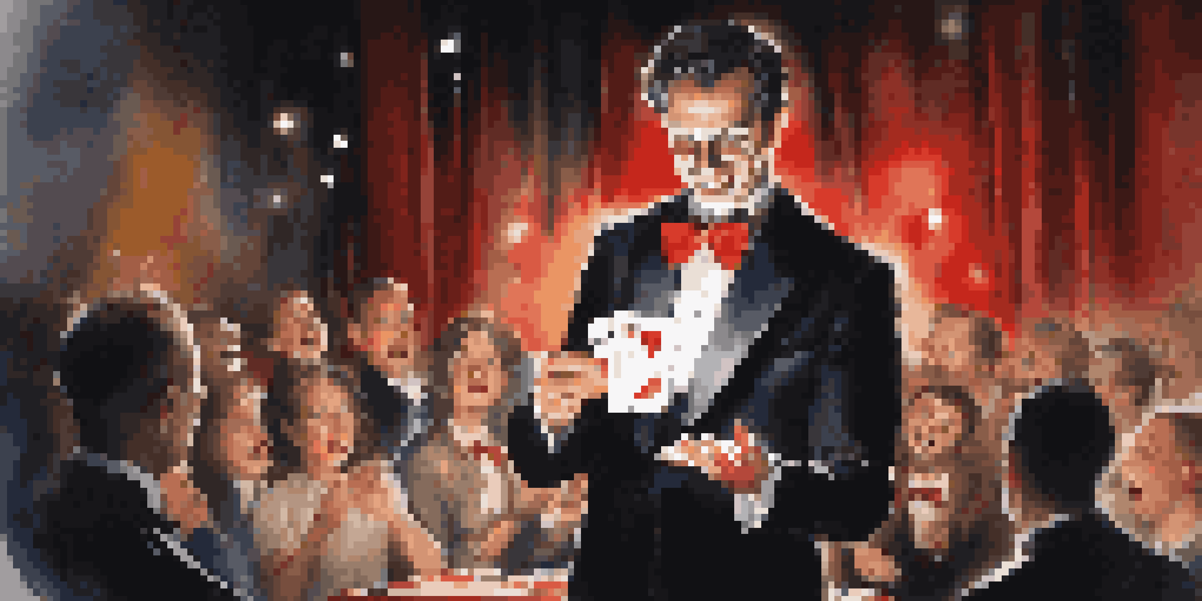 A magician in a tuxedo performing a card trick on stage, holding a deck of cards with a spotlight shining on them.