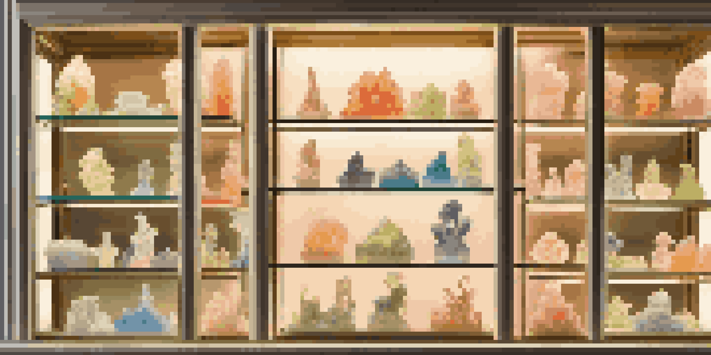 A glass display case filled with colorful and intricate soap sculptures, softly illuminated to showcase their details.