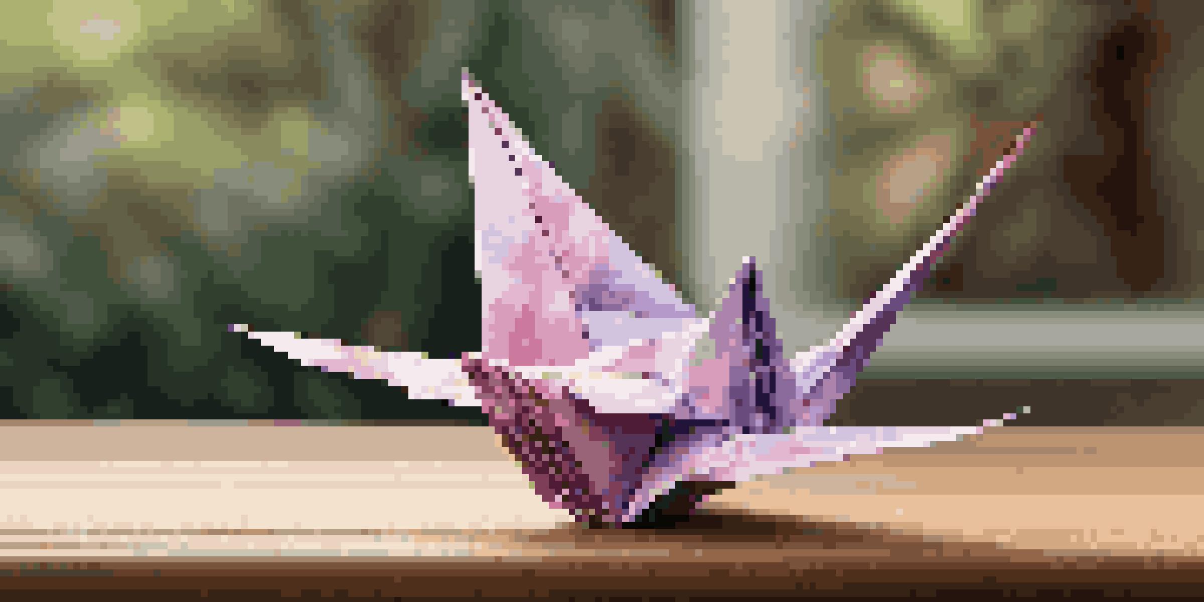 A detailed view of an origami crane on a wooden surface, surrounded by a blurred garden background.