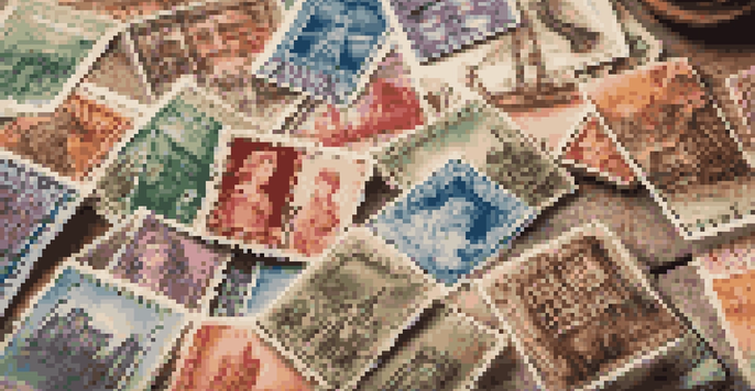 A close-up view of a vintage stamp collection on a wooden table with natural light illuminating the intricate designs of the stamps.