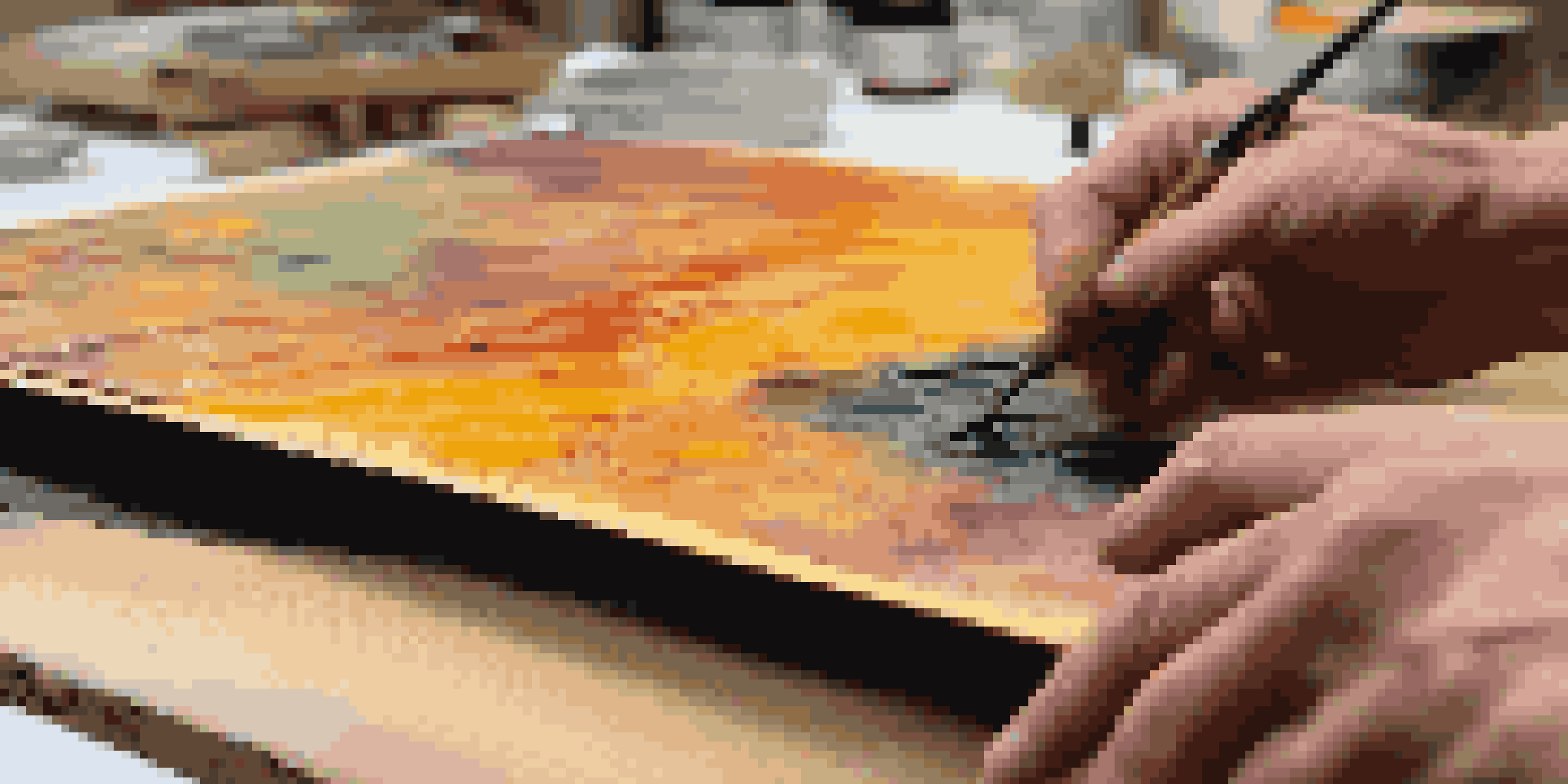 A close-up view of an encaustic painting process, with colorful beeswax layers and a palette under warm lighting.
