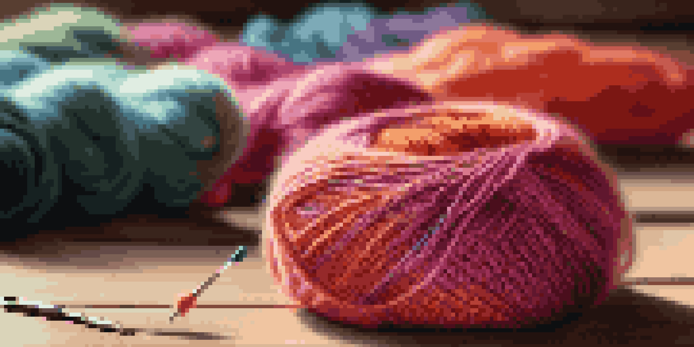 A colorful crochet hook and a skein of vibrant yarn on a wooden table, illuminated by warm light, with a partially finished crochet project in the background.