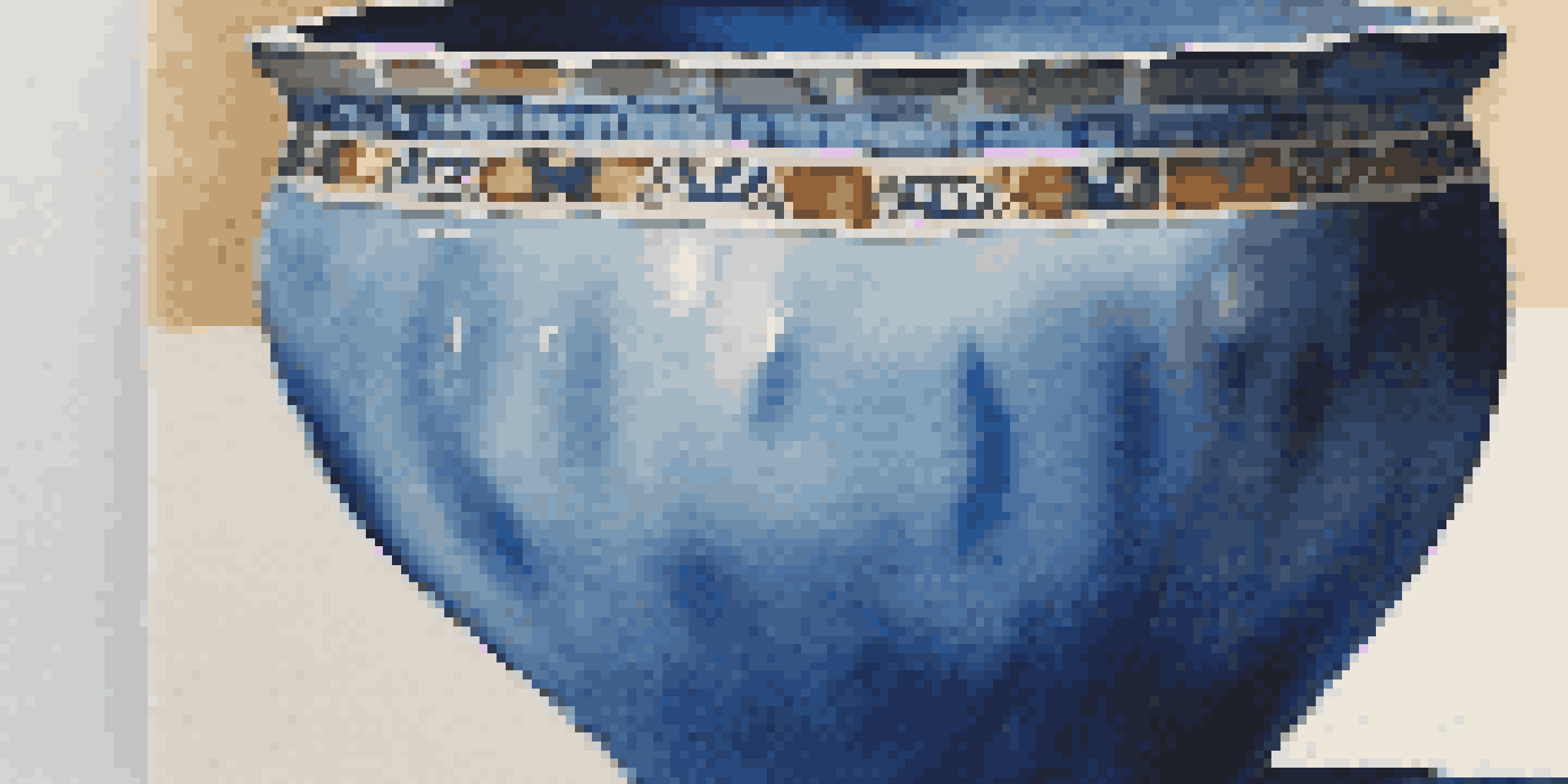 Close-up of a pottery piece with a glossy blue glaze, showing textures and color variations under natural light.