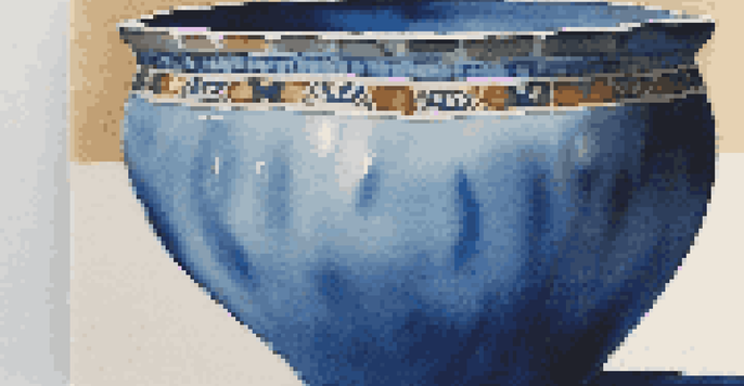 Close-up of a pottery piece with a glossy blue glaze, showing textures and color variations under natural light.