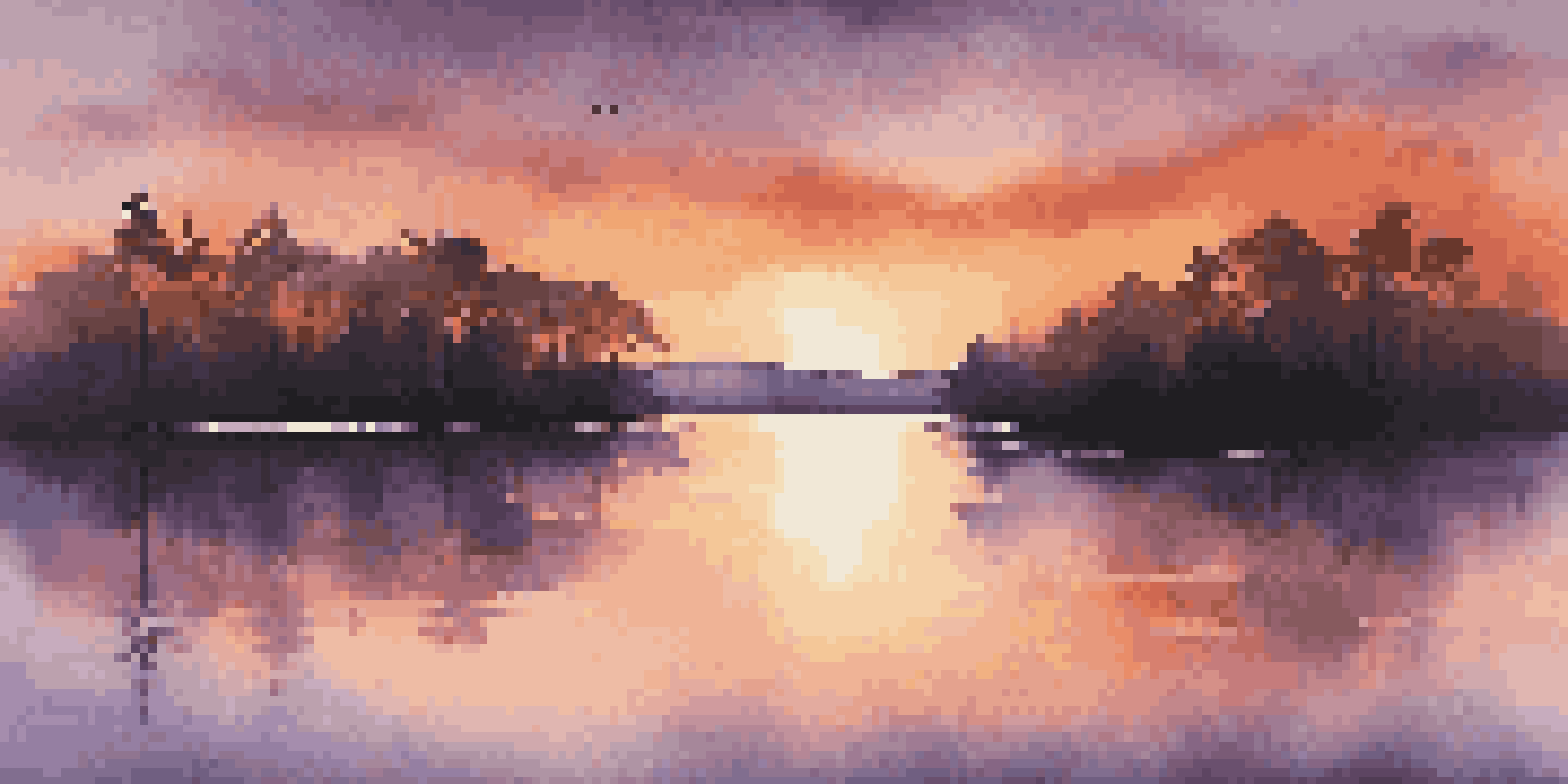 A colorful sunset casting reflections on a calm lake with silhouetted trees in the foreground.