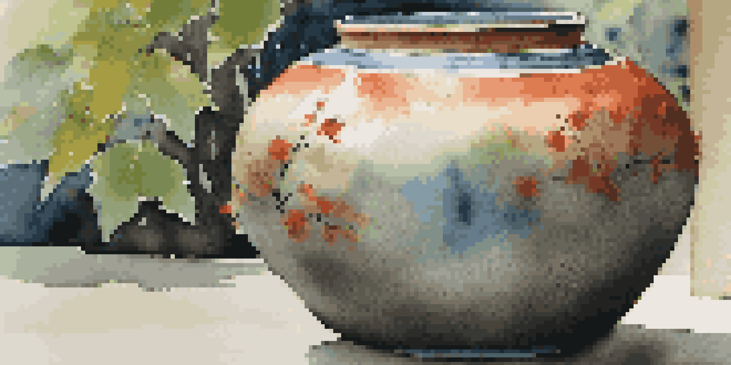 A close-up of a colorful Raku pottery piece in a tranquil garden setting, highlighting its textures and glazes.