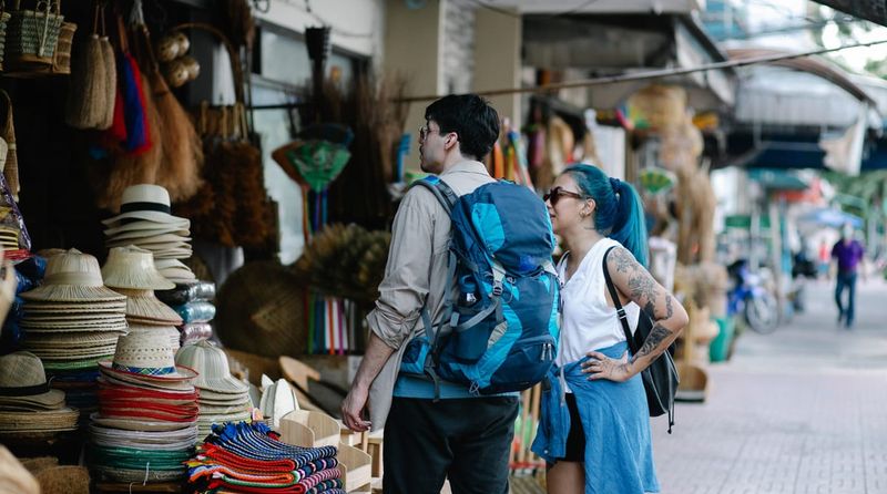 Two travellers browsing a street market