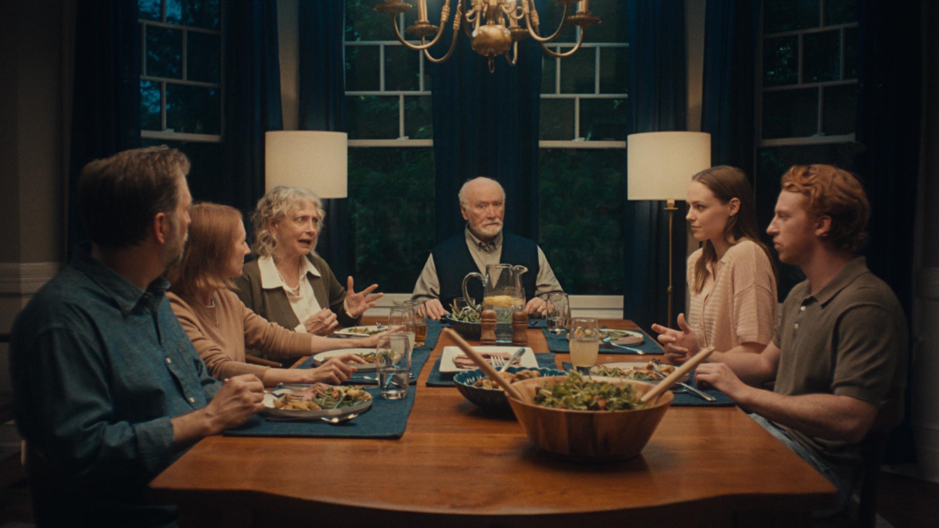 Family sitting around the dinner table with dubious expressions