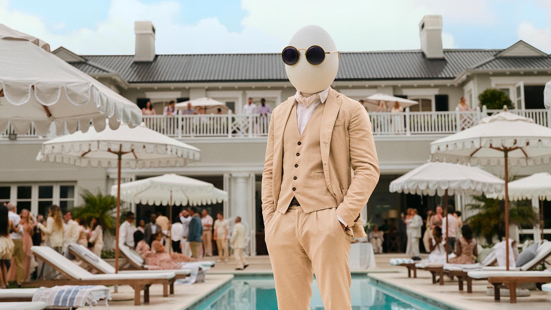 Hampton Dumpty in a suit in front of luxury pool