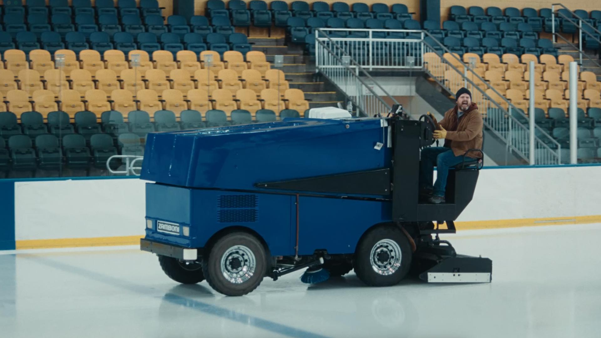 Hockey zamboni driving over the ice in a hockey rink