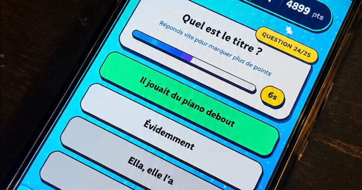 Un téléphone posé sur une table affiche une question musicale et les réponses proposées dans Vibzz.