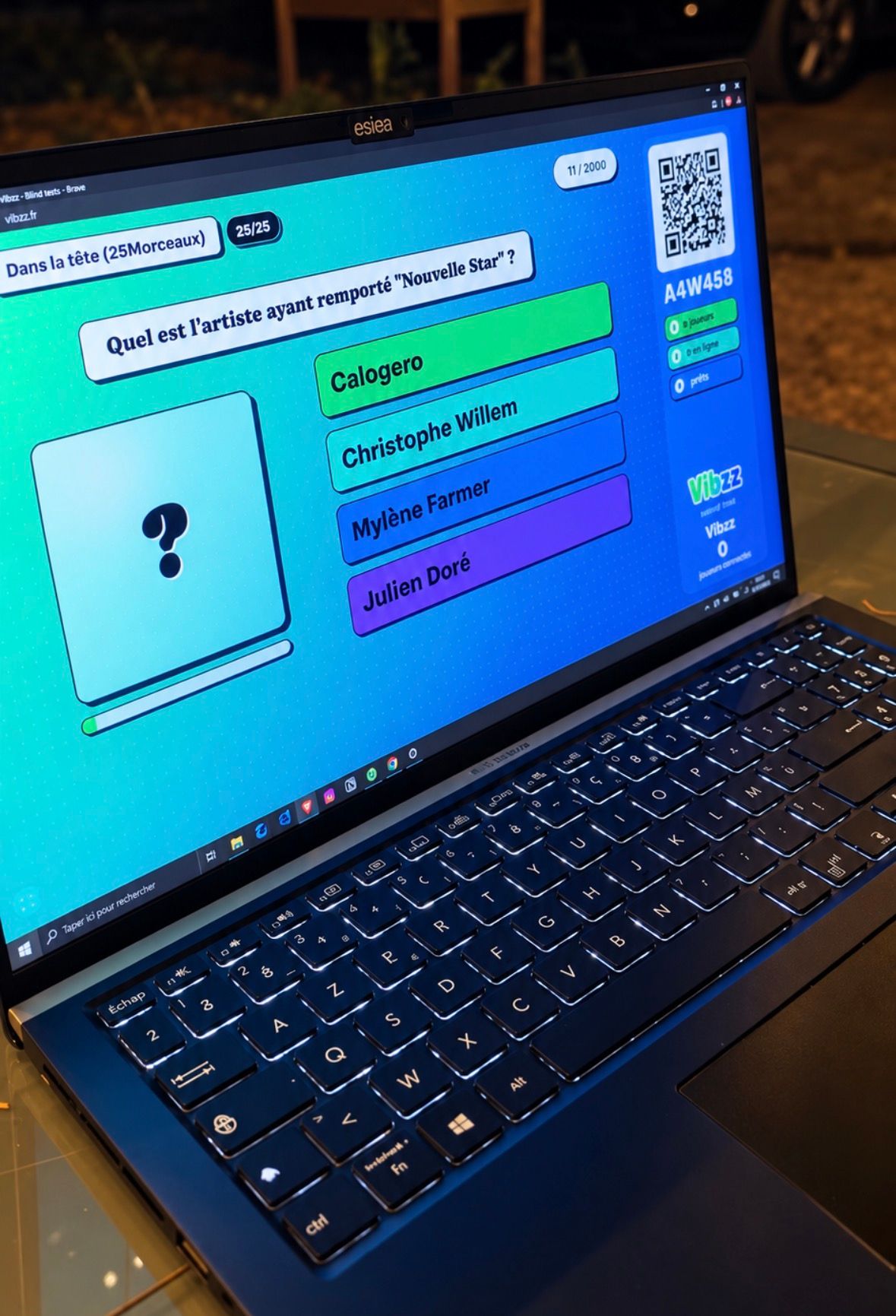 Ordinateur affichant une question de blind test Vibzz, un QR code et les réponses des joueurs.