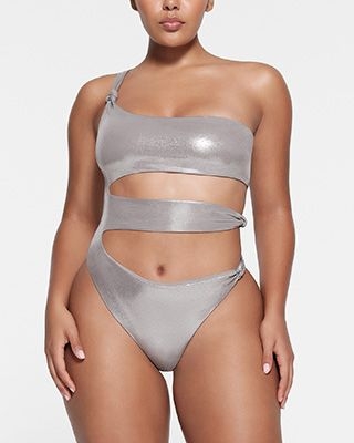 A model poses wearing SKIMS LIQUID SHINE SWIM