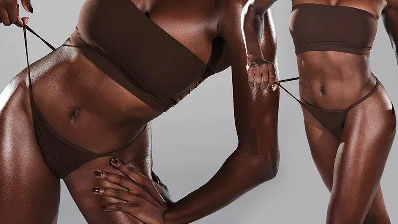 A female model poses wearing the Skims Fits Everybody T-String Thong in Cocoa
