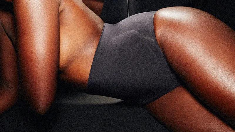 A model lays on her side wearing the Contour Bonded Brief in Onyx.
