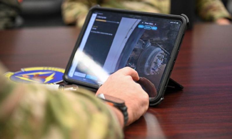 person in a military uniform shot from arm's length, interacting with the steering axle 3d model on a tablet