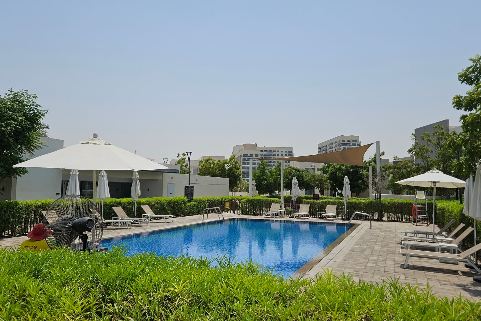 Community swimming pool and shaded loungers at Golf Links, Emaar South