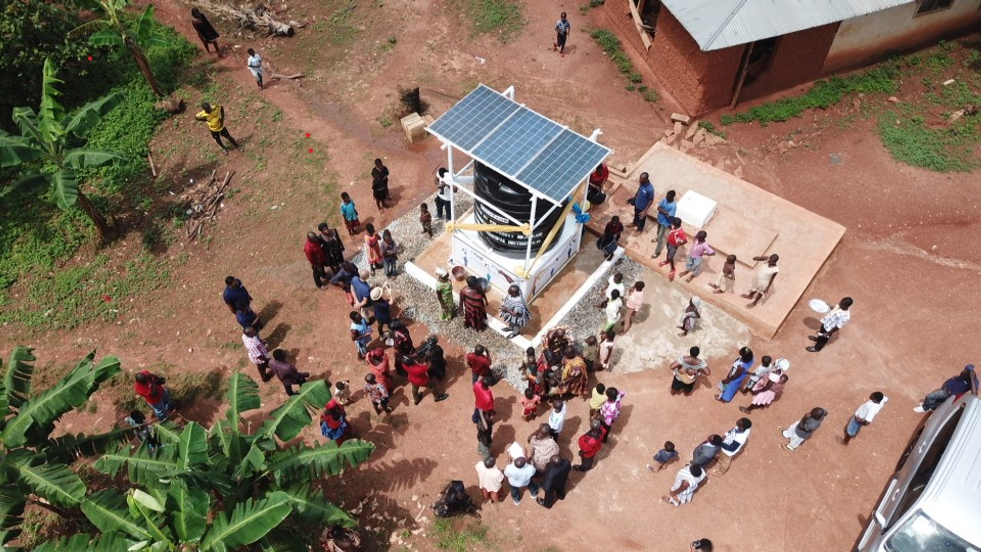 Aerial view of a crowd gathered around a solar-powered water kiosk