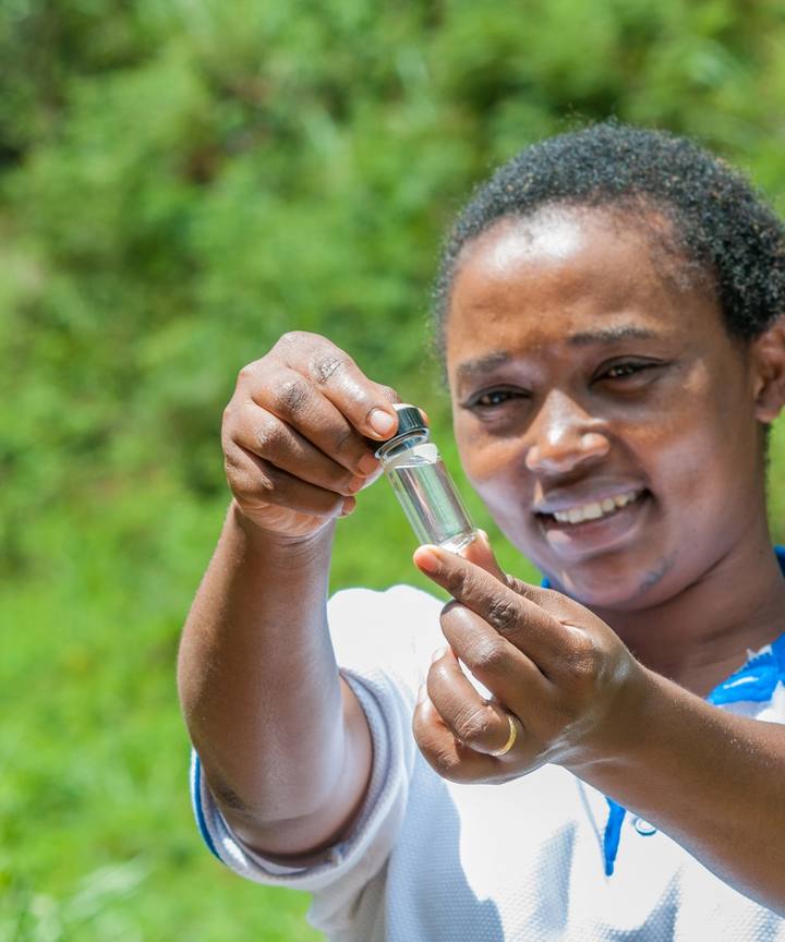 A water technician holding up a sample tube of clear water.