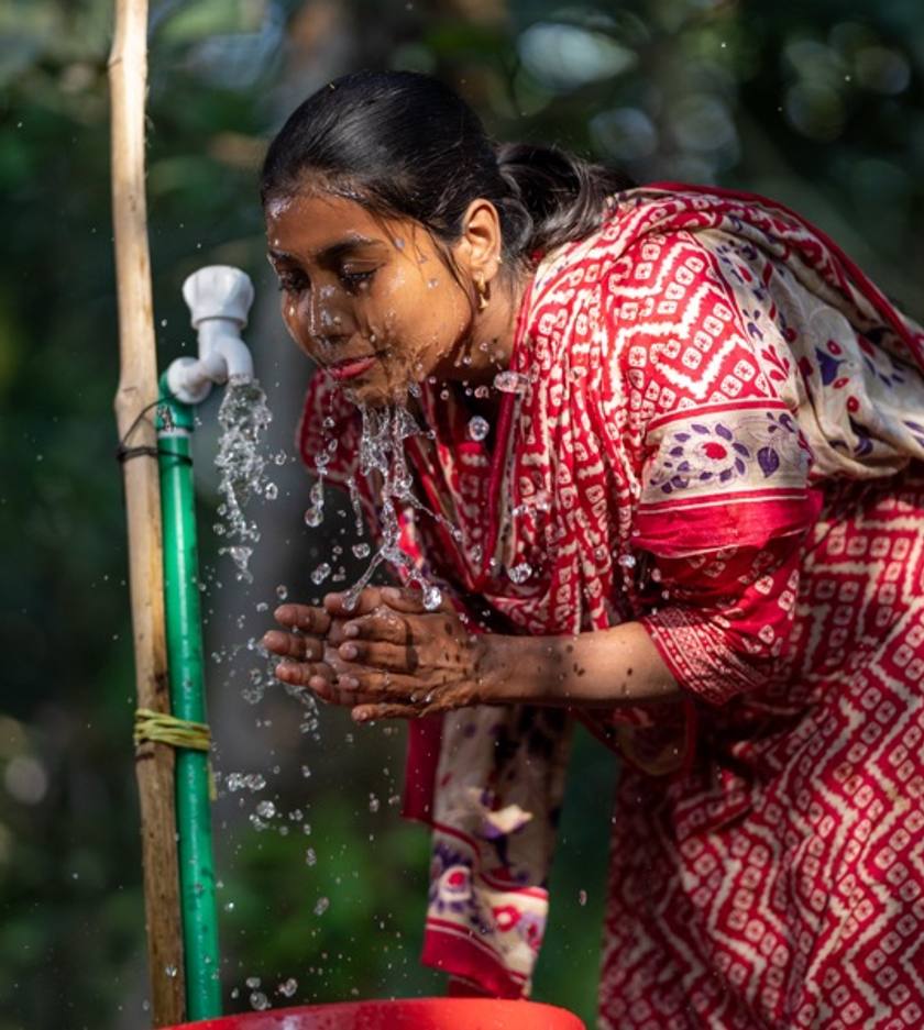 A woman fills a jerrycan at a tap.
