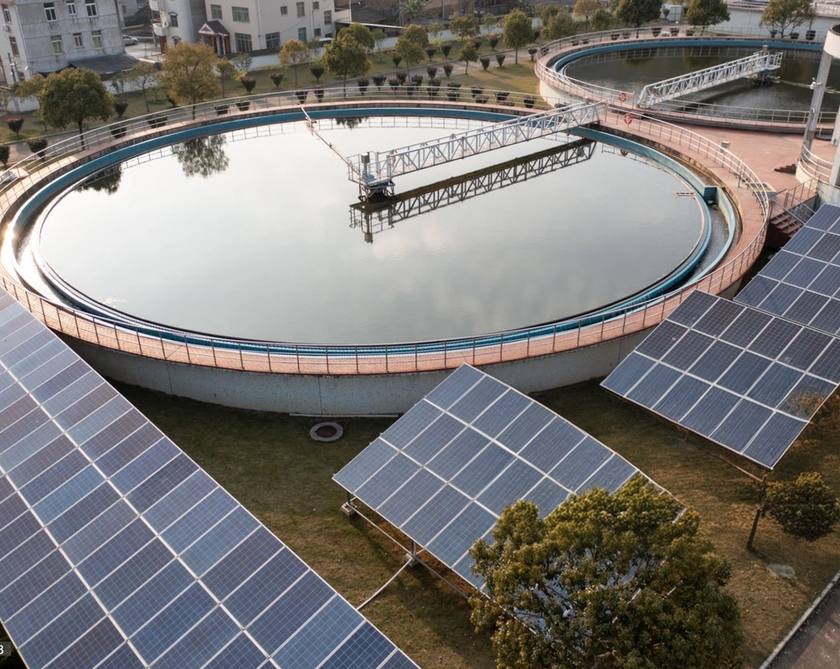 Solar panels beside the tanks of a water treatment plant